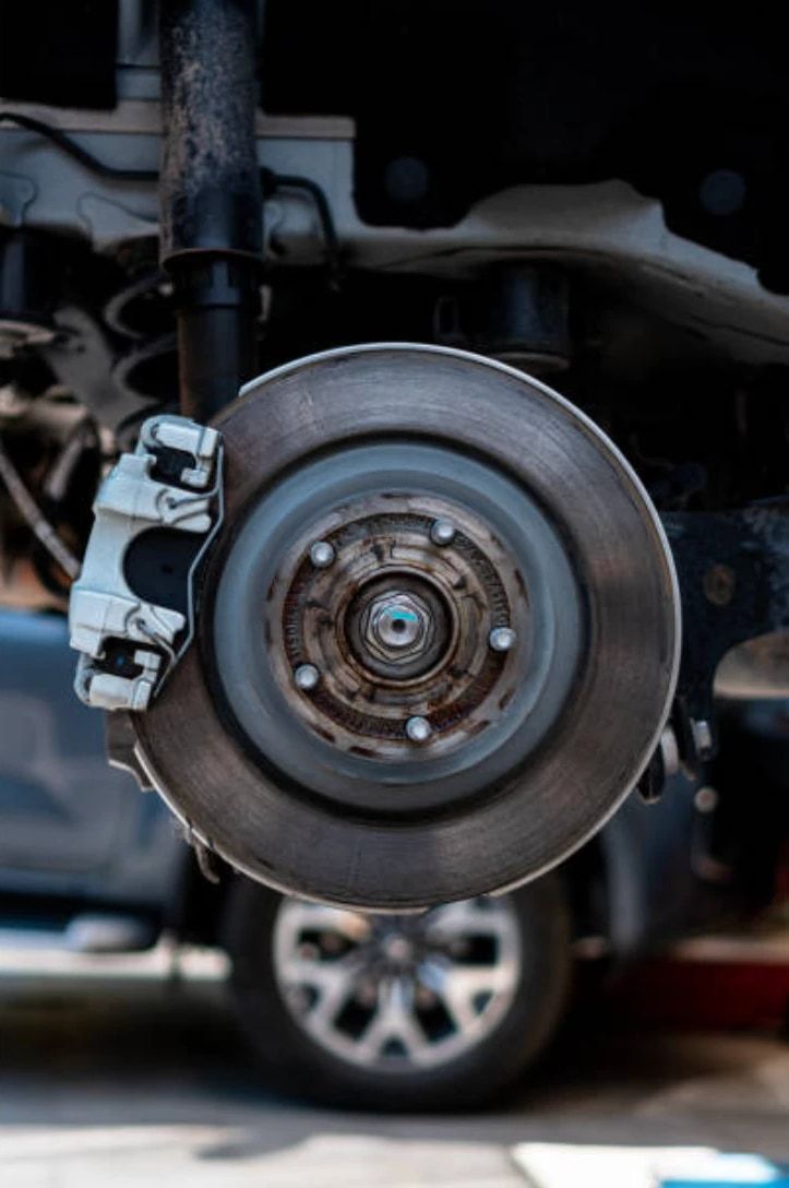 Brake rotor and caliper on a raised vehicle with the wheel removed